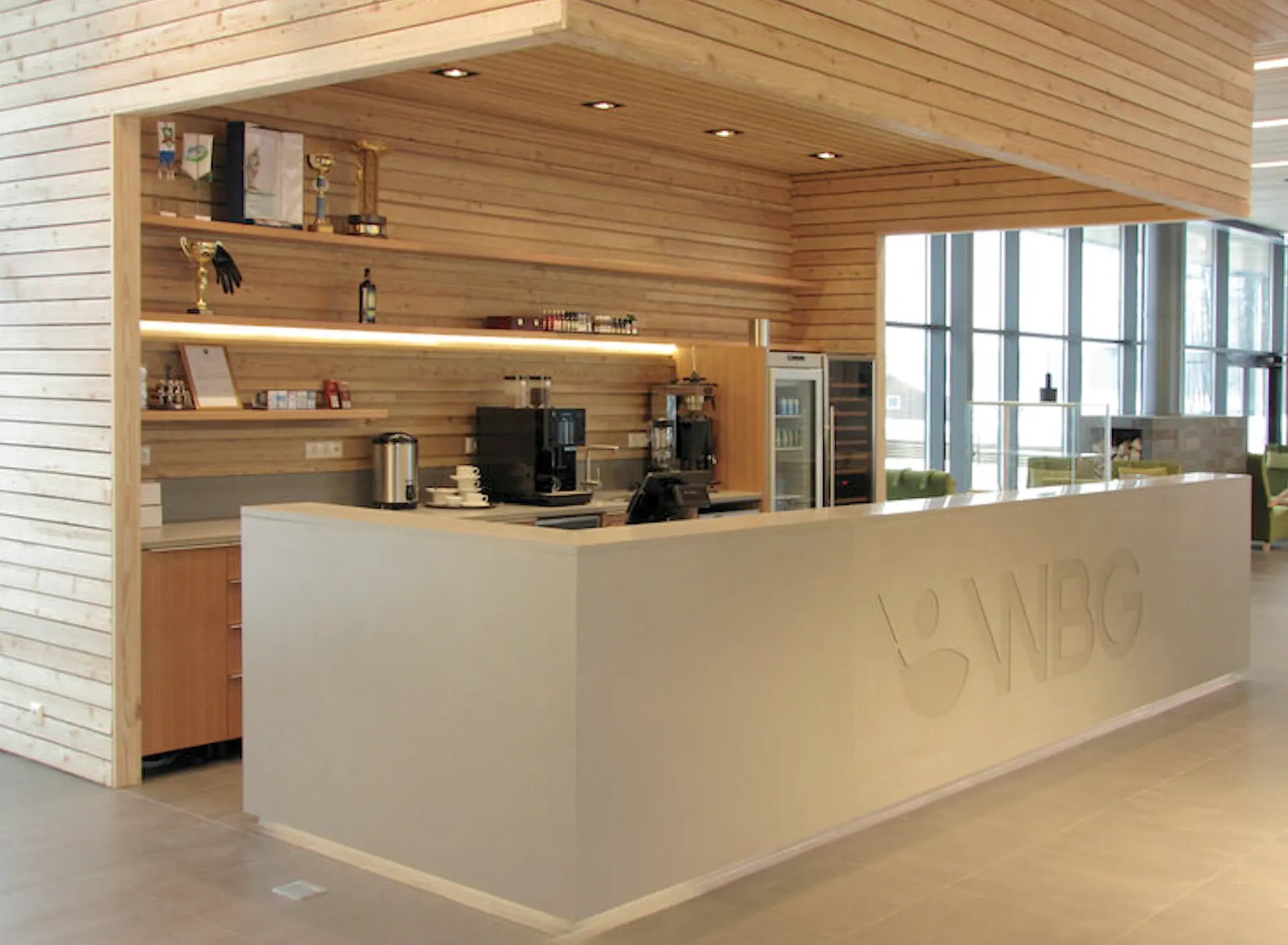 Ljus receptionsdisk med panelklädda väggar och hyllor i en nisch