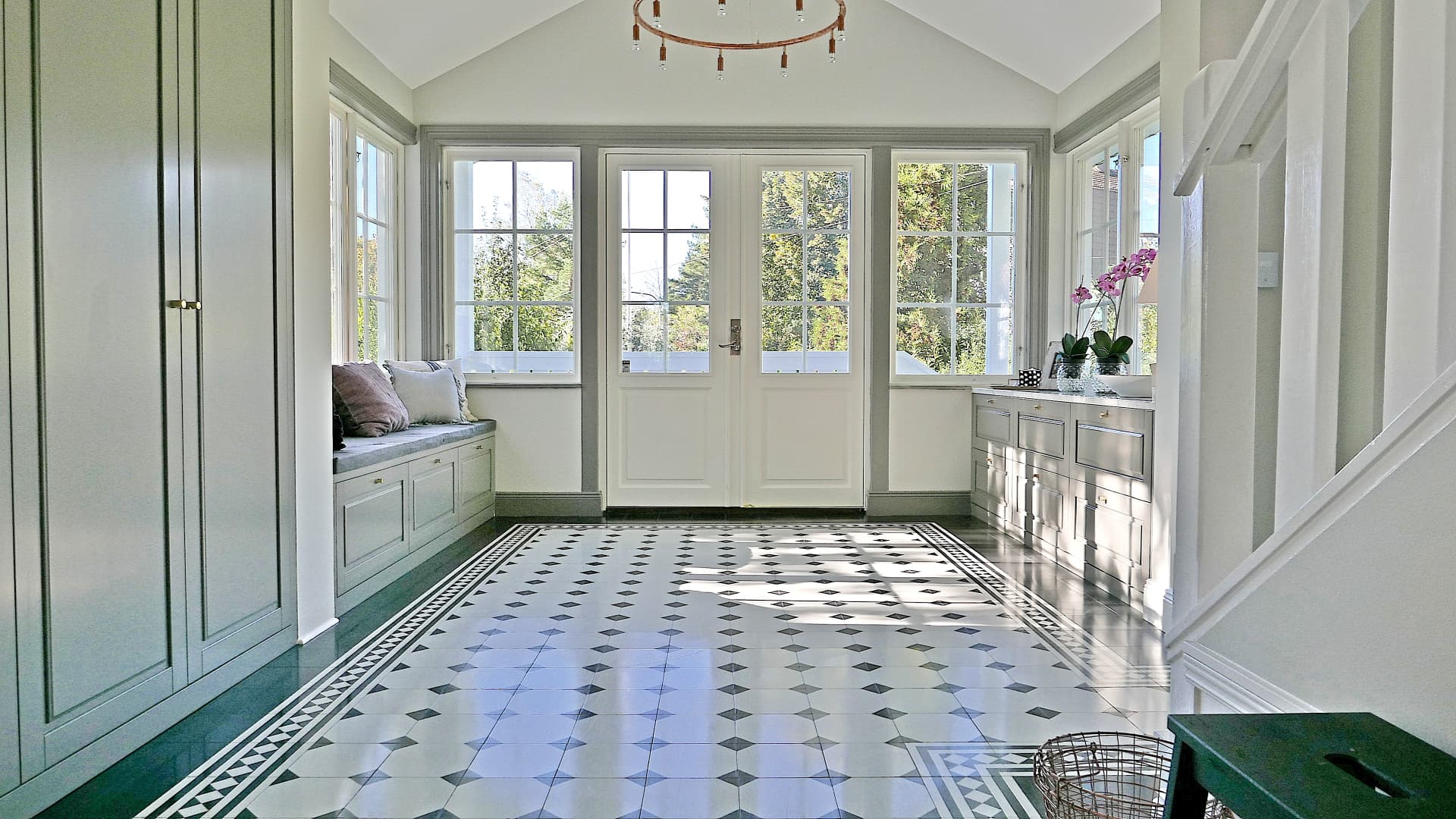 Light-filled classic entryway with built-in wardrobe, a window seat and a staircase
