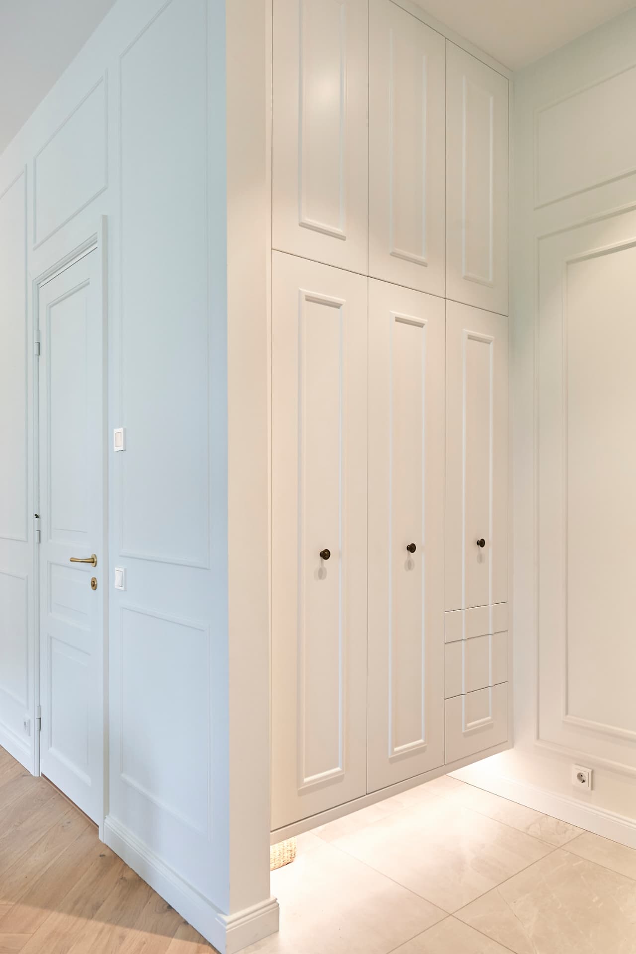 White wardrobe built into a hallway wall