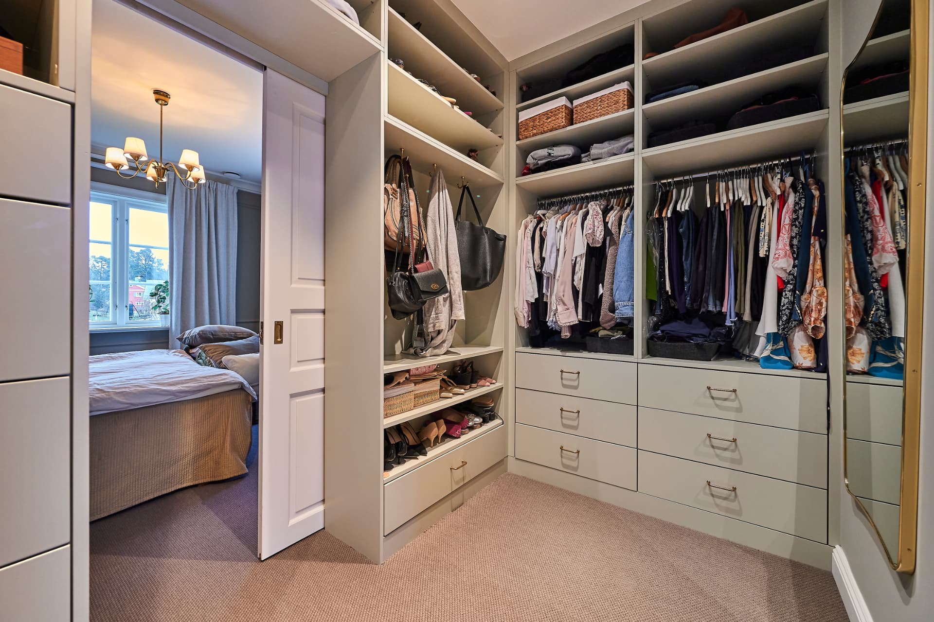 Walk-in wardrobe connected to the bedroom with open storage solutions