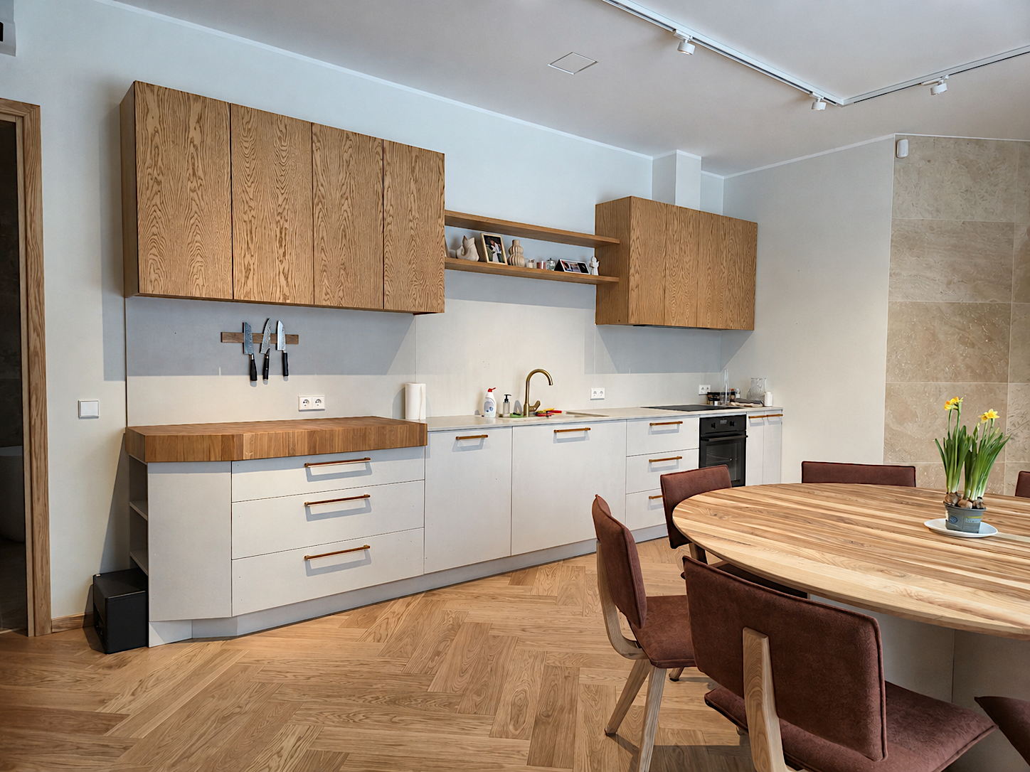 Oak kitchen with upper cabinets next to a round dining table