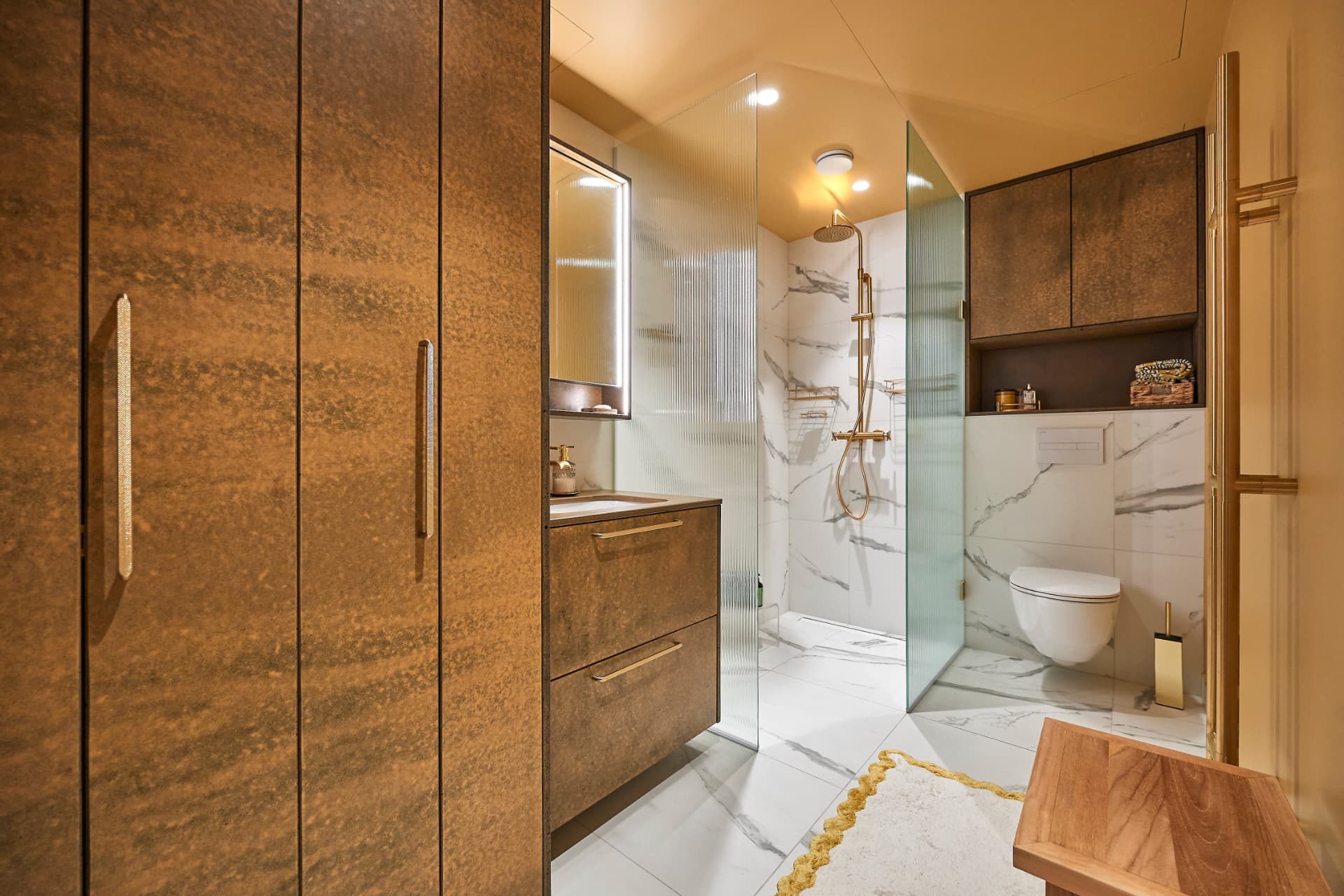 Bathroom with built-in wooden cabinets, a vanity unit and a glass shower corner