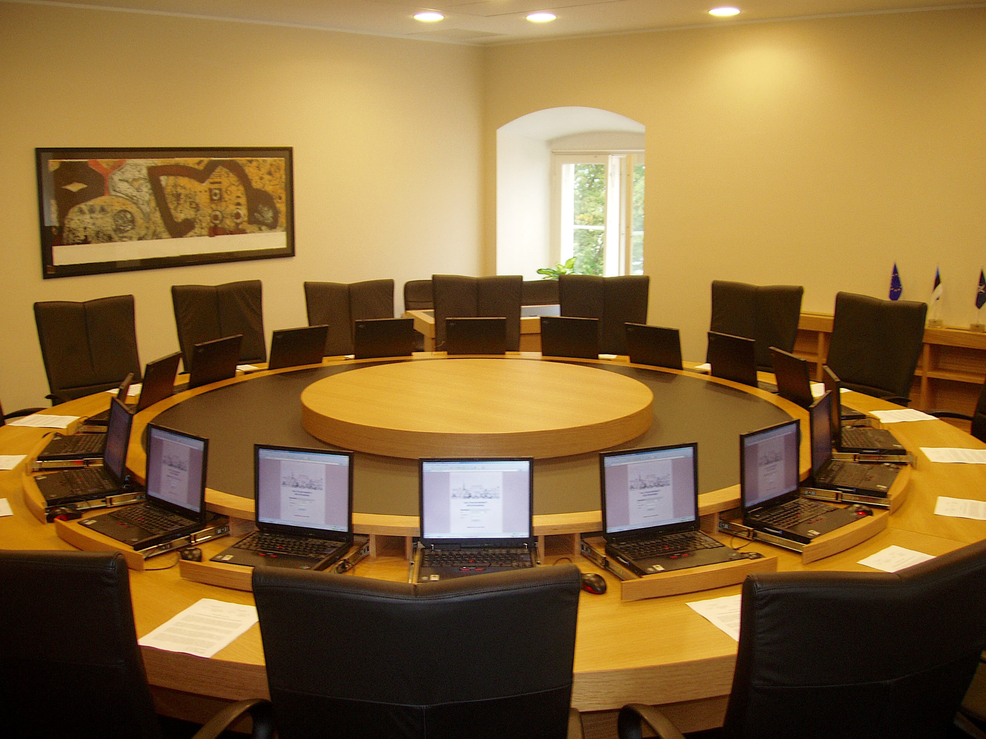 Mötesrum med ett runt konferensbord i trä